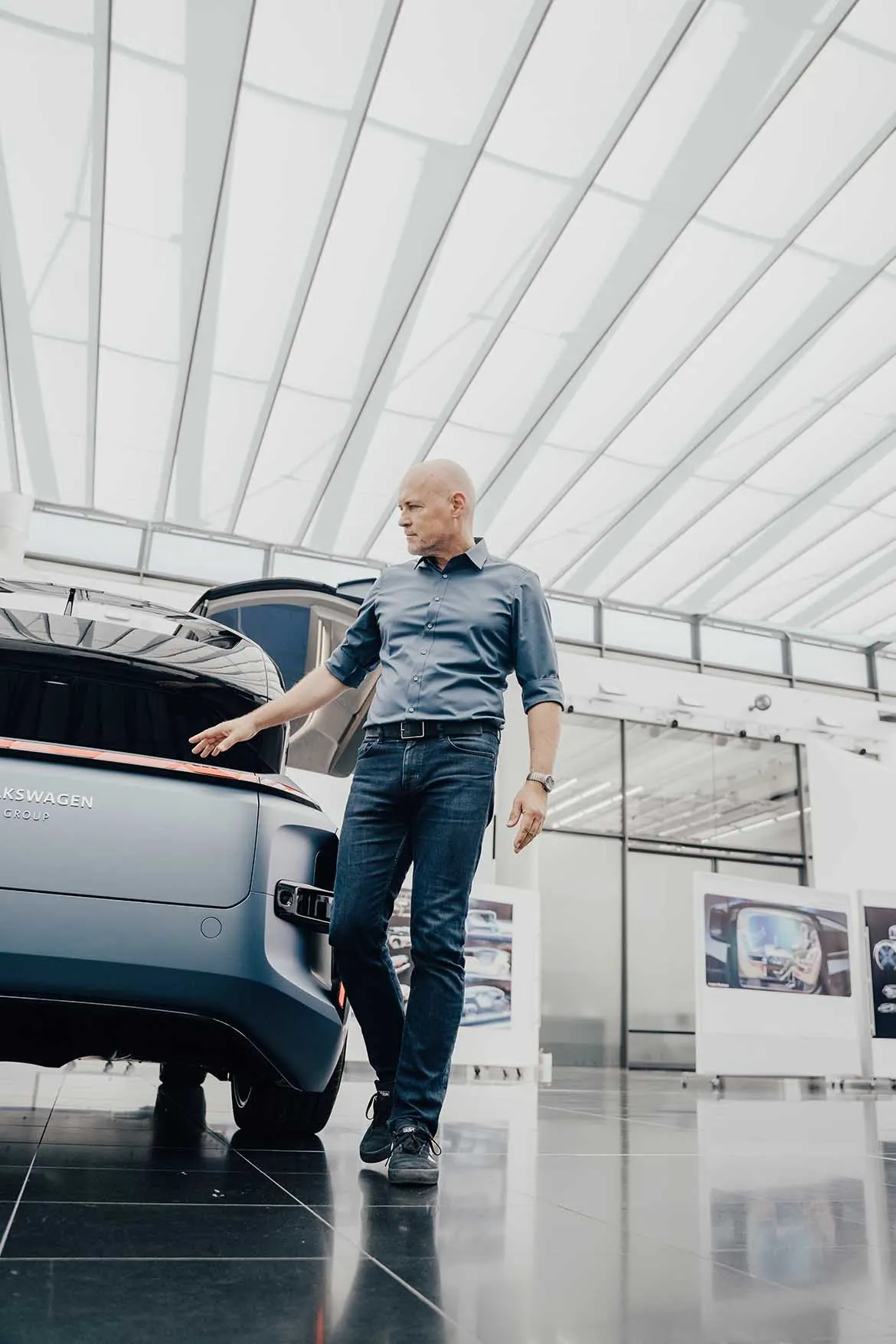 Volkswagen-Designer neben dem GEN.TRAVEL in einer lichtdurchfluteten Halle